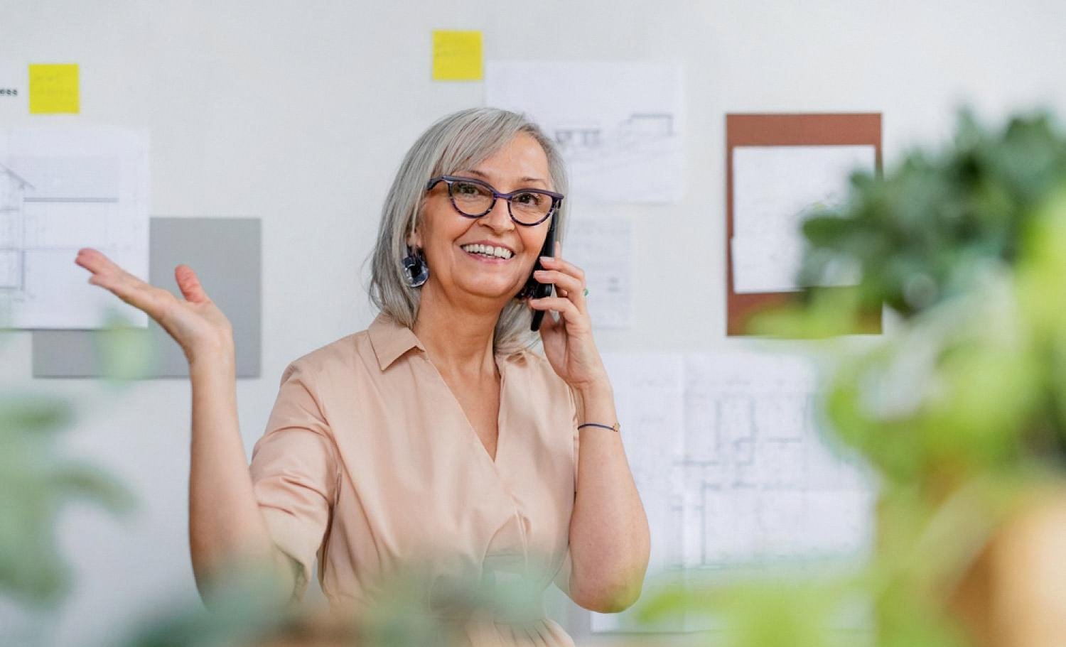 Smiling businesswoman on a phone call in a comfortably cooled UAE office